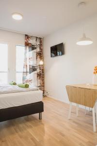 Dormitorio con cama, escritorio y TV en First aparthotel Blitzen, en Rovaniemi