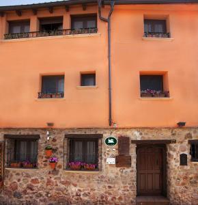 an orange building with windows and flower boxes at La Casa de Lucas in Clavijo
