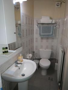 a bathroom with a white toilet and a sink at Eviali Apartments in Limne