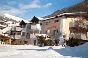 a large building in the snow in front of a mountain at Apart Austria in Nauders