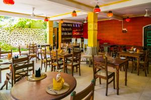 an empty restaurant with wooden tables and chairs at Thambapanni Retreat in Unawatuna