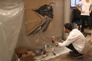 a man is painting a wall in a room at Hotel Lucerna in Castiglione della Pescaia