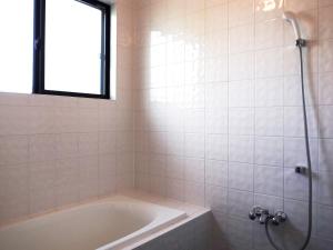 天草的住宿－Amakusa Port Ebisu House -天草 自然素材の一軒家えびすHOUSE-，一间带浴缸和淋浴的浴室,并设有一个窗户