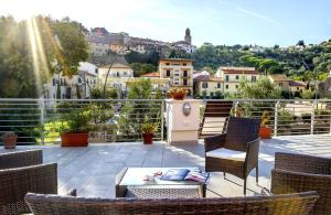 eine Terrasse mit Stühlen und einem Tisch auf dem Balkon in der Unterkunft Hotel Lucerna in Castiglione della Pescaia