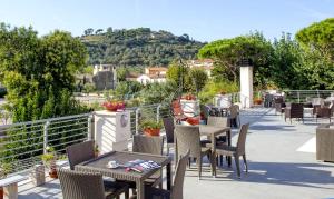 a patio with tables and chairs with a view at Hotel Lucerna in Castiglione della Pescaia