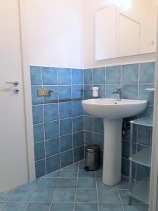 マリネッラにあるAppartamento sul mareの青いタイル張りのバスルーム(シンク、鏡付)