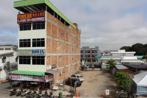 um grupo de motociclos estacionados fora de um edifício em Town Inn Hotel em Jerantut