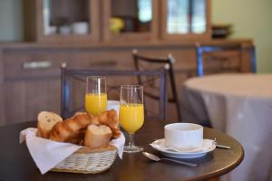 a table with a basket of bread and two glasses of orange juice at Hotel Cyrnea in Calvi