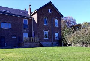 a large brick house with a grass yard at Vic Va la Vie in Éprave
