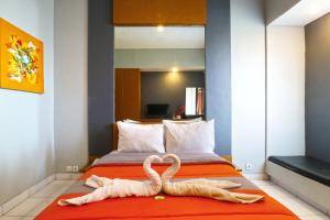 zwei Schwäne aus Handtüchern auf einem Bett in der Unterkunft Sayang Residence 2 in Denpasar