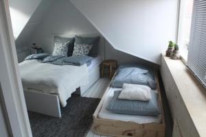 a bedroom with a bed and twounks in a attic at Appartement 4 Seasons Katwijk aan Zee in Katwijk aan Zee