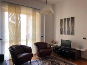 a living room with two chairs and a television at Casa Roma in Turate