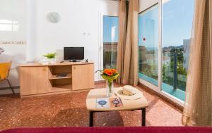 a living room with a table and a large window at Apartaments Els Llorers in Lloret de Mar