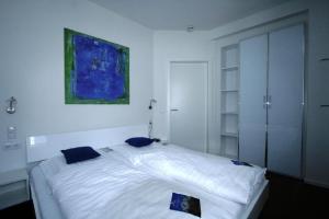 a bedroom with a large white bed with blue pillows at Ferienwohnung-Am-Kurpark-Wohnung-1-60qm in Garmisch-Partenkirchen