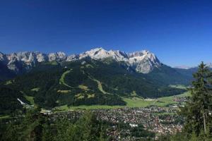 a valley with a town and mountains in the background at Ferienwohnung-Am-Kurpark-Wohnung-1-60qm in Garmisch-Partenkirchen