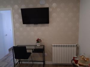 a room with a desk and a television on a wall at H.Albar Mieres in Mieres