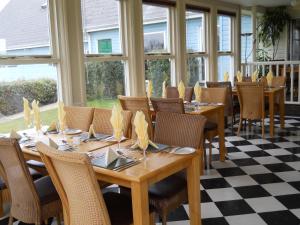 a dining room with tables and chairs and windows at Richmond Park Golf Club in Watton