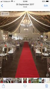 a banquet hall with a red carpet and chairs at Amble Inn Guest House in Empangeni