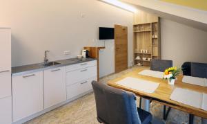 eine Küche und ein Esszimmer mit Tisch und Stühlen in der Unterkunft Gästehaus Alte Glaserei in Neustadt an der Weinstraße