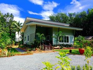 ein kleines grünes Haus mit Kieseinfahrt in der Unterkunft Sunbeam Cottage in Ko Chang