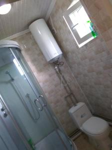 La salle de bains est pourvue d'une douche, de toilettes et d'une fenêtre. dans l'établissement Talants Guest House, à Bishkek