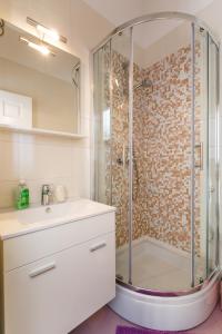 een badkamer met een douche en een wastafel bij Apartment Iris & Elena in Pinezici