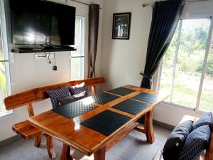 a living room with a table and a tv at Sunbeam Cottage in Ko Chang