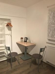 a kitchen with a table and two chairs and a table with a tea kettle at Rooms Miki in Zagreb