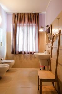 a bathroom with a sink and a toilet and a window at Albergo Trattoria Italia in Desenzano del Garda