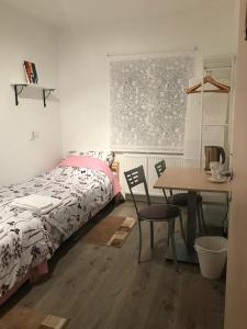 a bedroom with a bed and a desk and a table at Rooms Miki in Zagreb