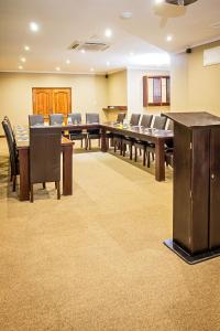 una sala de conferencias con una mesa larga y sillas en Nolangeni Hotel, en Kokstad