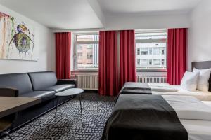 a hotel room with a bed and a couch at ProfilHotels Mercur in Copenhagen