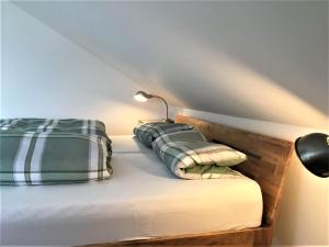 a bed with two pillows and a lamp on it at Eulennestle in Lenzkirch