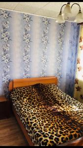 イヴァノヴォにあるЧетырехкомнатная квартира на Любимова 8の青い壁のベッドルーム1室(ヒョウ柄のベッド1台付)