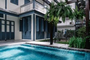 a swimming pool in front of a building at Baan Vajra in Bangkok