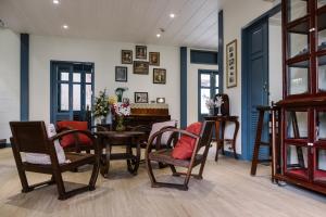 a dining room with chairs and a table and a room with blue walls at Baan Vajra in Bangkok
