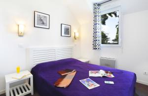 a bedroom with a purple bed and a window at Terres de France Le Domaine de la Baie in Audierne +31 photos