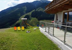 ein Haus mit einem Spielplatz an der Seite eines Berges in der Unterkunft AlpenHit Saalbach in Saalbach-Hinterglemm