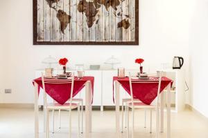comedor con mesa roja y sillas en Villa Rosina en Rho