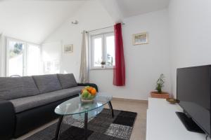 a living room with a couch and a glass table at Hedera Estate, Hedera A52 in Dubrovnik