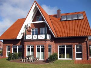 Logierhaus-Greetsiel 1 في غريتسيل: منزل على السطح مع لوحات شمسية