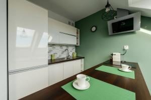 a kitchen with a wooden table with two cups on it at Studio Kopernika in Iława