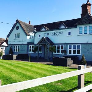 a white inn with a fence in front of it at The Falcon At Hatton in Hatton