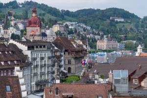Blick auf eine Stadt mit Gebäuden und einem Uhrturm in der Unterkunft Capsule Hotel - theLAB in Luzern