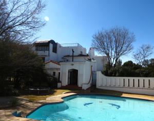 a swimming pool in front of a house at Kleineweide Boutique Estate in Pretoria