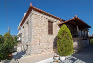 a stone house with a window and two trees at "En Hatipi" in Sparti