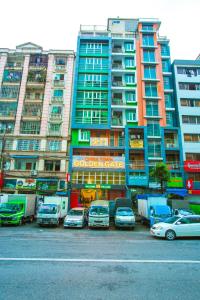 a parking lot with cars parked in front of tall buildings at Golden Gate China Town Hotel in Yangon
