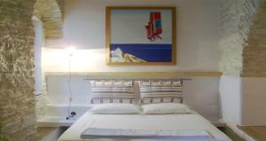 a bedroom with a white bed with a picture on the wall at Villa Kardiani in Kardhianí