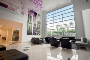 a waiting room with chairs and a large window at Tequendama Hotel Medellín - Estadio in Medellín