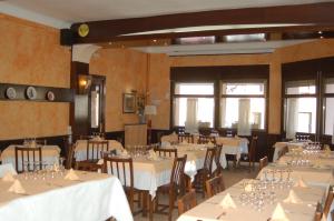 uma sala de jantar com mesas e cadeiras com toalha de mesa branca em Hotel Betriu em Coll de Nargó